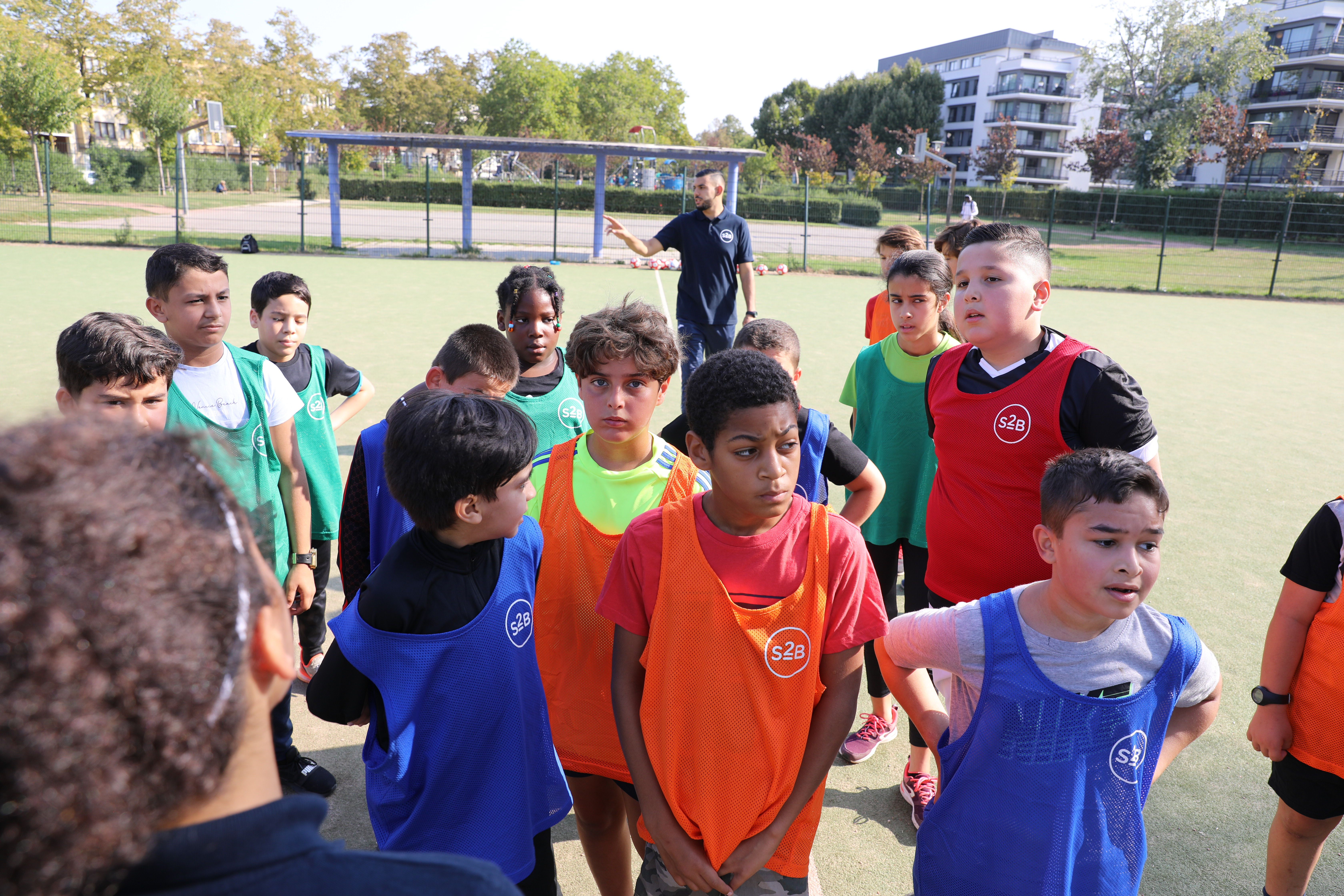 Young footballers listening to their coach during a free football training session by Sport2Be
