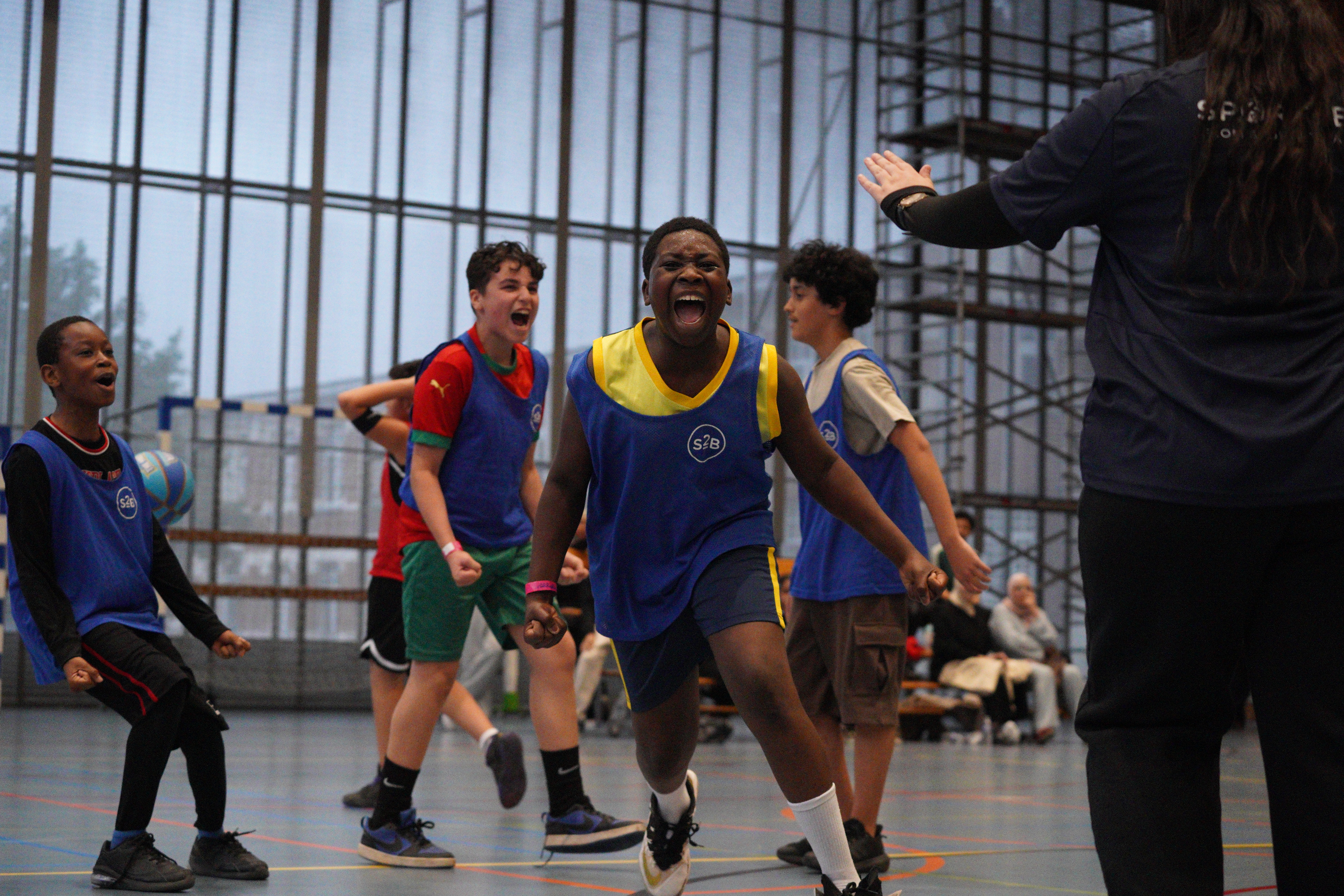 3 young Brussels teenagers celebrating their goal at the basketball tournament